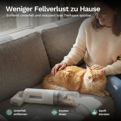 Frau pflegt Katze auf Sofa und entfernt lose Tierhaare mit Handstaubsauger, reduziert Fellverlust und sorgt für saubere Wohnumgebung.