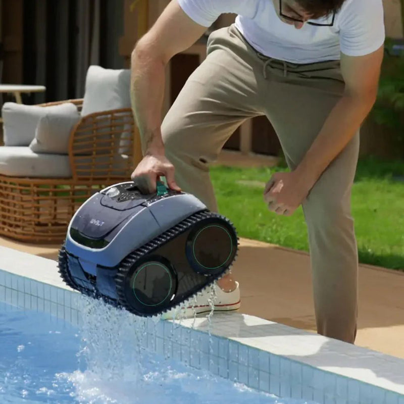 Mann hebt einen Poolreinigungsroboter aus dem Wasser und entleert ihn am Beckenrand.